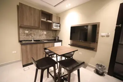a kitchen with a table and chairs in a room at فندق صحارى الخليج Sahara Gulf Hotel Apartments in Amman