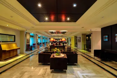 a lobby of a hotel with couches and a piano at Century Park Hotel in Amman