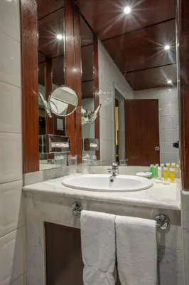 a bathroom with a sink and a mirror and towels at Century Park Hotel in Amman