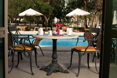 a table and chairs with a table and a pool at Century Park Hotel in Amman