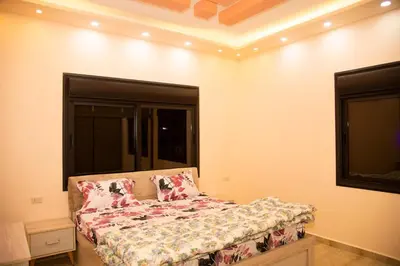 a living room with a couch and a window at Lotus housing for furnished apartments in Jerash