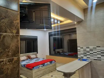 a bedroom with a bed and a wooden table at Lotus housing for furnished apartments in Jerash