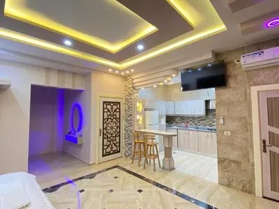 a living room with a tv on a ceiling at Lotus housing for furnished apartments in Jerash