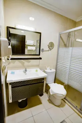 a bathroom with a sink and a toilet and a mirror at AQABA COAST HOTEL in Aqaba