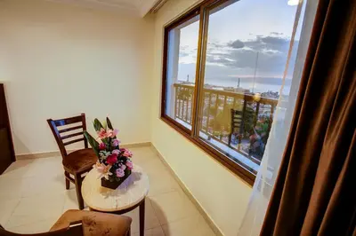 a room with a table and a window with flowers on it at AQABA COAST HOTEL in Aqaba