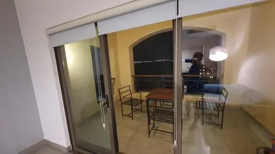 a room with a table and chairs and a sliding glass door at Comfy Stays Sea View Apartments at DeadSea Samarah Resort in Sowayma