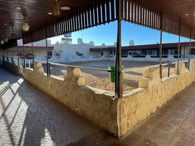 a large building with a wall with a fence at Petra Royal Ranch in Wadi Musa