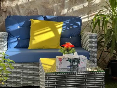a blue couch with yellow cushions on a table at Petra Royal Ranch in Wadi Musa