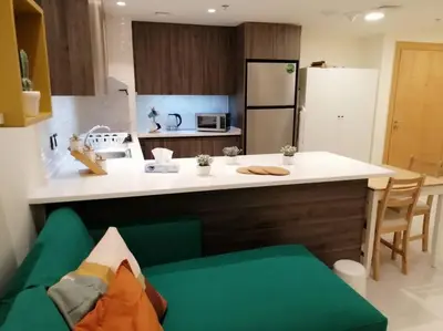 a kitchen with a white counter top and a kitchen with a refrigerator at Amazing Studio in DAMAC in Amman