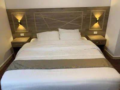 a bedroom with a large bed with two night stands at Asad Apt. in Wadi Musa