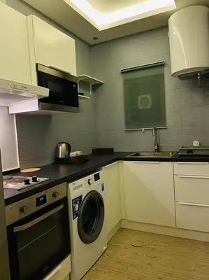 a kitchen with a washing machine and a sink at Elite Corner Apartment in Ţāb Kirā‘