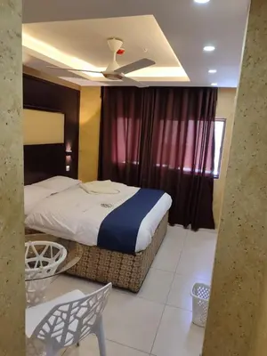 a bedroom with a bed and a ceiling fan at Roza Beach Aqaba in Aqaba