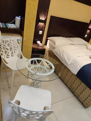a bedroom with a bed and a glass table and chairs at Roza Beach Aqaba in Aqaba
