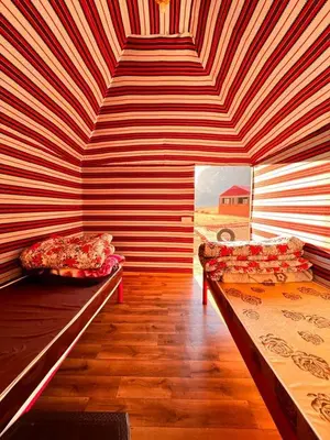 a room with two beds and a striped wall at Wadi Rum White Mountain Camp in Wadi Rum