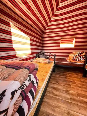 two beds in a room with red and white stripes at Wadi Rum White Mountain Camp in Wadi Rum