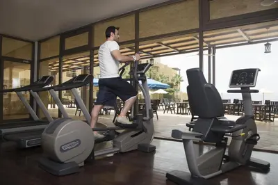 a man running on a treadmill in a gym at Spacious apartments with Sea view at Samarah Resort in Sowayma