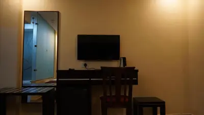 a room with a desk with a television and a chair at petra agora hotel in Wadi Musa