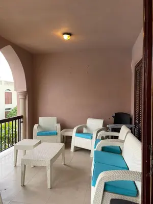 a room with chairs and tables on a balcony at Romantic chalet between swimming pools and close to the seashore for families only in Aqaba