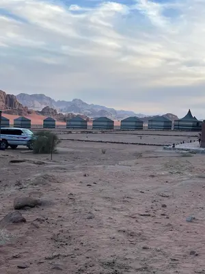 a desert with a car parked in a field at Bedouins nights in Wadi Rum