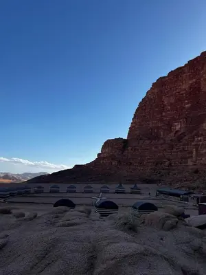 a building in a desert with a mountain in the background at Bedouins nights in Wadi Rum