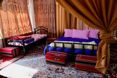 a bedroom with a bed and two chairs and curtains at private room with cultural experience and great landscapes in Şirfah
