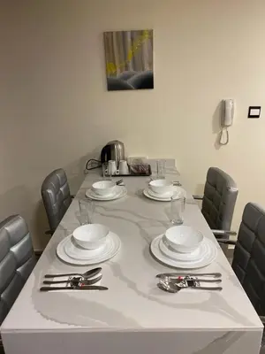 a table with white plates and silverware on it at Luxury Apartment in DAMAC Towers in Amman