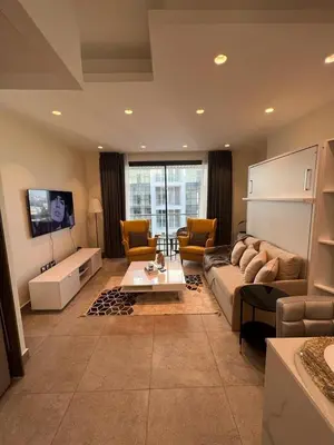 a living room with a couch and a tv at Luxury Apartment in DAMAC Towers in Amman