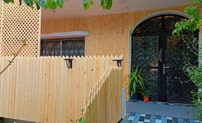 a house with a wooden fence and a black door at Petra Pillars Way Hostel in Wadi Musa