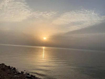 a sunrise over the water with the sun in the sky at Samarah Dead Sea Resort Studio-CP6 Traveler Award 2026 Winner Thursday, Friday and Saturday Groups consisting solely of male guests are not permitted in Sowayma