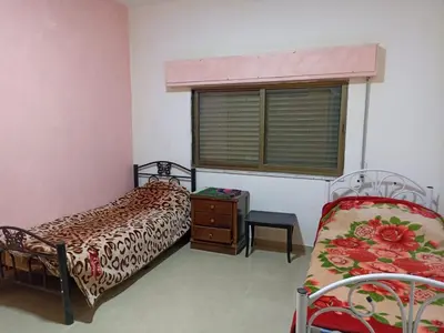 a bedroom with two beds and a window at Economic Apartment in Az Zarqa