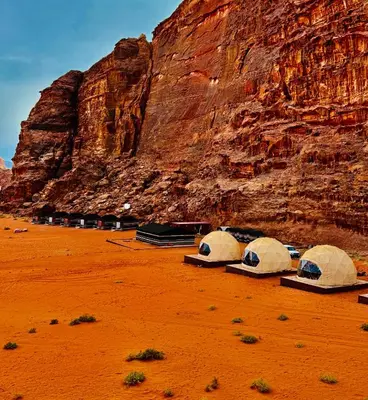 a group of tents in the desert next to a mountain at Wadi rum Bubble Camp & tour in Wadi Rum