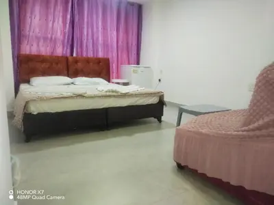 a bedroom with a bed and a chair at Farah Plaza Hostel &Hotel Apartments in Aqaba