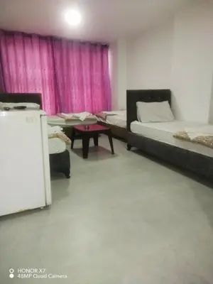 a room with two beds and a table in it at Farah Plaza Hostel &Hotel Apartments in Aqaba