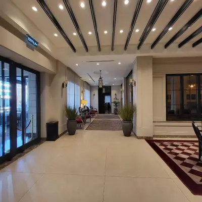 a lobby of a hotel with a hallway with potted plants at Ambassador, a Boutique Hotel in Amman
