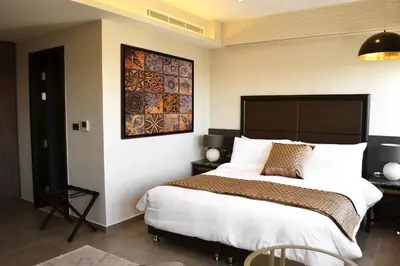 a bedroom with a large bed and a painting on the wall at Ambassador, a Boutique Hotel in Amman