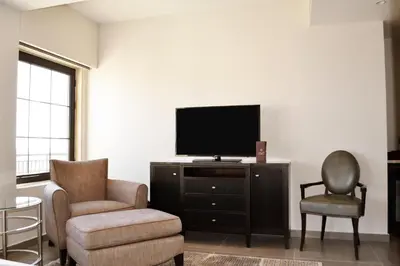 a living room with a tv and a chair at Ambassador, a Boutique Hotel in Amman