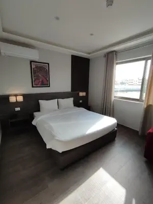 a bedroom with a large bed and a window at Black Iris Hotel II in Madaba
