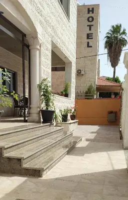 a building with wooden steps in front of a building at Black Iris Hotel II in Madaba