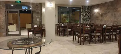 a restaurant with a table and chairs in a room at Black Iris Hotel II in Madaba