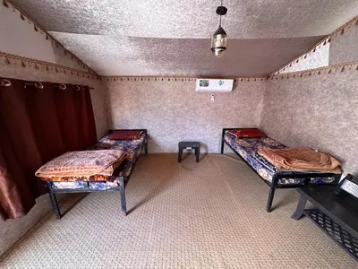a room with two beds in the corner of a room at Wadi Rum Oryx Hostel & Tours in Wadi Rum