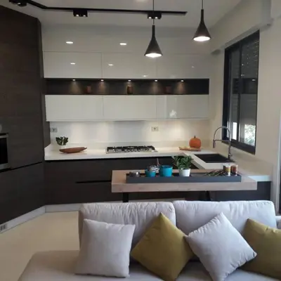 a living room with a white couch and a kitchen at Exquisite Modern 2-bedroom Rental Unit in Amman