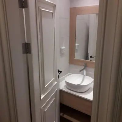 a bathroom with a white sink and a mirror at Exquisite Modern 2-bedroom Rental Unit in Amman