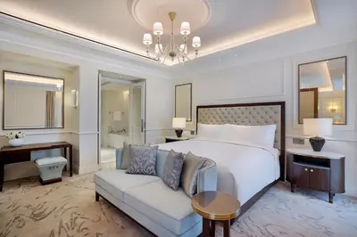 a bedroom with a bed and a couch and a desk at The Ritz-Carlton, Amman in Amman