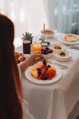 a person sitting at a table with a plate of food at The Ritz-Carlton, Amman in Amman