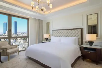 a bedroom with a large white bed and a large window at The Ritz-Carlton, Amman in Amman