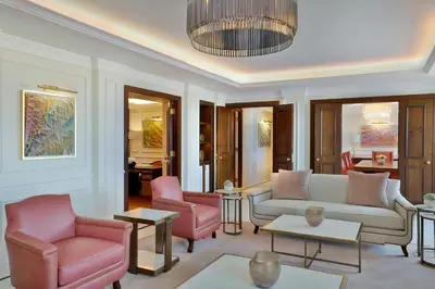 a living room with a white couch and pink chairs at The Ritz-Carlton, Amman in Amman
