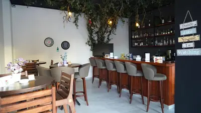 a restaurant with a bar with tables and chairs at Aitch Boutique Hotel - an LIH Hotel in Madaba