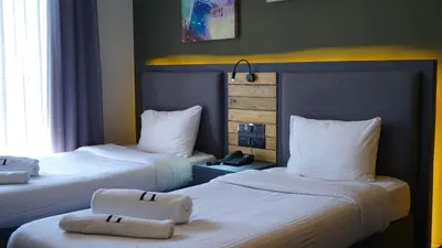a hotel room with two beds with towels on them at Aitch Boutique Hotel - an LIH Hotel in Madaba