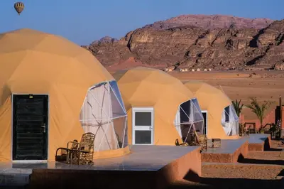 a row of dome tents in the desert at Qimam Al Sarab Camp Wadi Rum in Wadi Rum