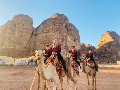 a group of people riding on camels in the desert at Rum Four Seasons luxury Camp & Jeep Tours in Wadi Rum
